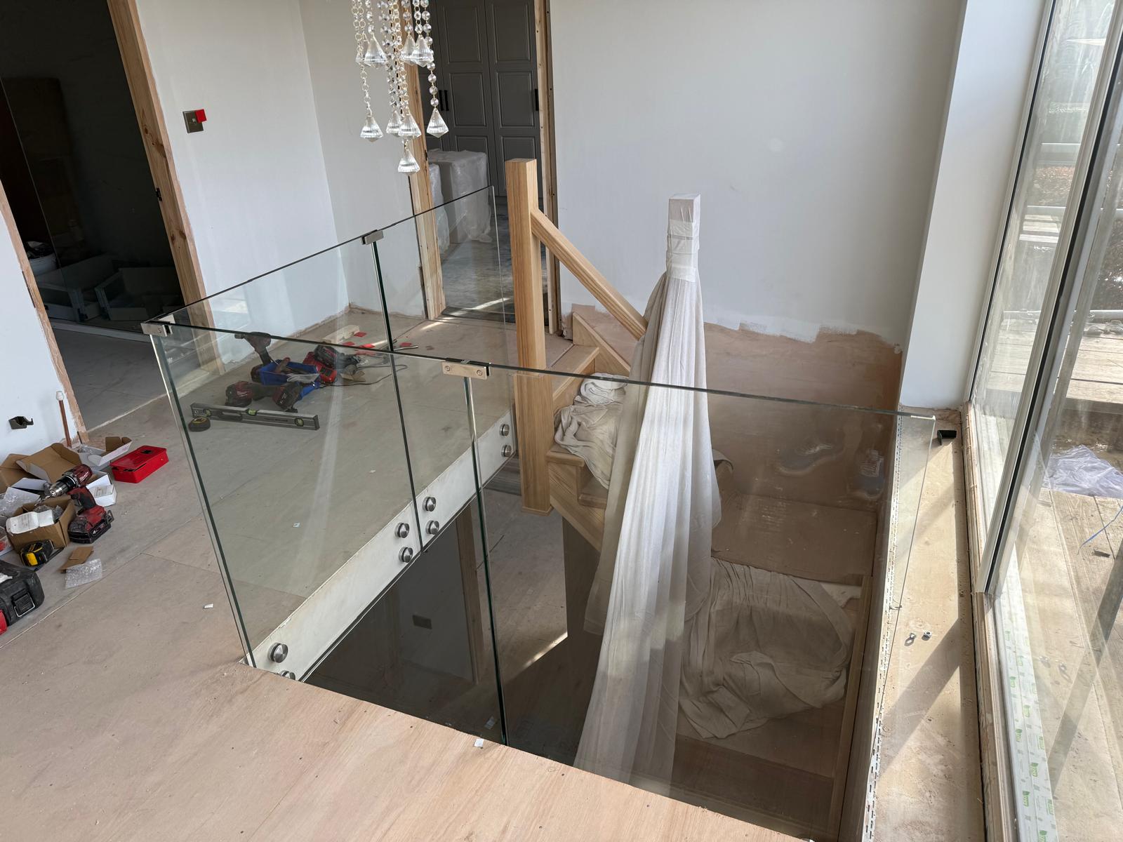 Glass balustrade with oak handrail on residential stairwell